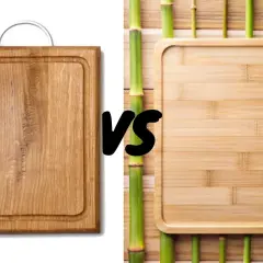 A sturdy acacia wood cutting board faces off against a sleek bamboo board, surrounded by vibrant green bamboo stalks.