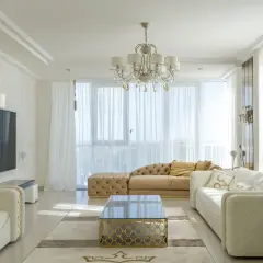 Elegancki salon z białymi sofami i złotymi akcentami. Czy można łączyć srebro ze złotem w domu? Tak, tworząc luksusową przestrzeń.
