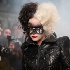 Cruella med "The Future" skrivet i ansiktet, omgiven av fotografer.