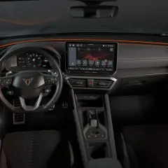 Interior del Cupra Formentor con pantalla táctil, volante deportivo y luces ambientales naranjas.
