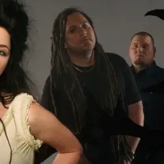 Amy Lee z Evanescence, z jej charakterystyczną fryzurą, wpatruje się w obiektyw. Obok niej stoją członkowie zespołu, gotowi by "bring me to life".