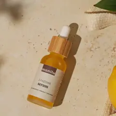 Szukasz idealne serum do twarzy po 50.? Na zdjęciu dwufazowe serum z kwasem hialuronowym, witaminą C i olejem marula, obok cytryny i liści.