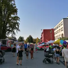Menschen genießen das Stadtfest Bergisch Gladbach bei Sonnenschein. Einsatzfahrzeuge und Stände säumen die belebte Straße.