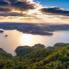 Zachód słońca nad jeziorem Solina. Widać zalesione wzgórza, wyspy i zatoczki. Idealne miejsce na odkrywanie atrakcji Solina i okolice.