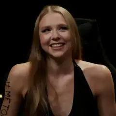 Uśmiechnięta Maja Staśko, której wiek nie jest widoczny, z napisem #METOO na ramieniu.