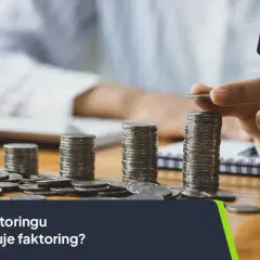Faktoring co to? Ręka układa monety w słupki, symbolizując koszty faktoringu. Sprawdź, ile kosztuje faktoring.