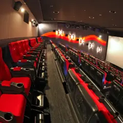 Puste czerwone fotele kinowe z logo 4DX czekają na widzów.