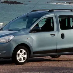 Auto blu con porte scorrevoli parcheggiata sulla costa. Ideale per avventure familiari al mare.