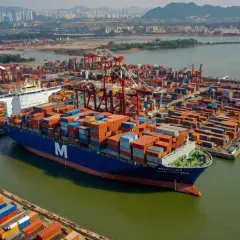 Großer Containerschiffhafen mit vielen Containern und Kränen. Ein Schiff mit dem "M"-Logo ist im Vordergrund. Ein Shipper nur, kein Verkäufer.