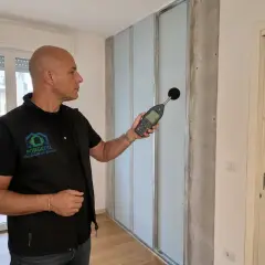 Tecnico misura rumore con fonometro per capire come non sentire la tv del vicino.