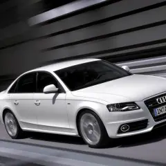 Białe Audi A4 B8 w ruchu, z widocznymi typowymi usterkami tego modelu, jak np. problemy z elektroniką.