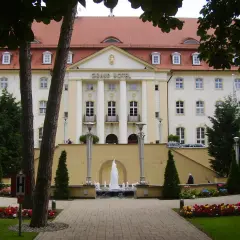 Grand Hotel z fontanną i ogrodem kwiatowym przed fasadą.