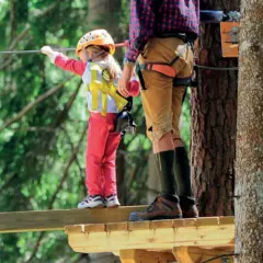 Un bambino e un adulto su un percorso avventura. Un perfetto weekend con bambini nel Nord Italia, tra alberi e adrenalina.