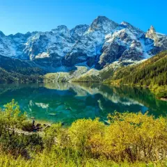 Piękne Morskie Oko, idealne na trasę. Lśniąca tafla jeziora odbija ośnieżone szczyty Tatr i jesienne lasy.