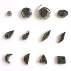 Różne kształty z papieru, pokazujące, quilling co to jest. Kółka, łezki, listki, księżyce, trójkąty i kwadraty.