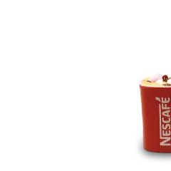 En röd Nescafé-mugg med en härlig mocka smak, toppad med marshmallows och choklad.