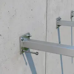 Solidne osadzenie kotwy w betonie. Metalowe wsporniki przymocowane do betonowej ściany, gotowe do montażu.