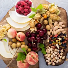 Ett uppdukat fat med frukt, bär och nötter – perfekt för ett nyttigt fika på jobbet. Här finns hallon, physalis, körsbär, nektariner, melon, bananchips, longan och en blandning av nötter och torkad frukt.