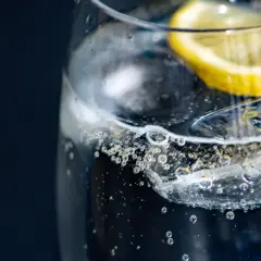 Szklanka z wodą gazowaną i plasterkiem cytryny. Czy woda gazowana jest zdrowa? Pytanie, na które odpowiedź może być zaskakująca.