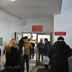 Ludzie w kolejce do punktu paszportowego w urzędzie.