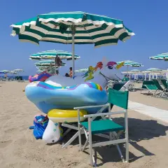 Spiaggia di Viareggio con gonfiabili a forma di unicorno e arcobaleno, pronti per i bambini.