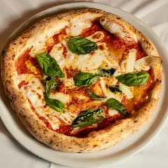 Margherita pizza z bazylią i mozzarellą. Czy wiesz, że ciekawostki o pizzy są równie pyszne jak ona sama?