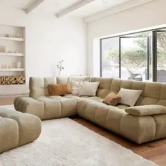 Gemütliches Wohnzimmer mit großem Ecksofa, Kamin und Blick in den Garten – ein Ausblick auf die wohntrends 2026.