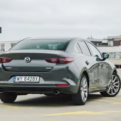 Szary sedan Mazda 3 na parkingu. Sprawdzamy mazda 3 spalanie i wrażenia z jazdy.