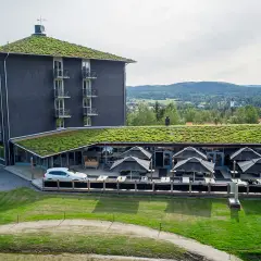 Modernt B&B Järvsö med gröna tak och utsikt över landskapet. Uteservering med parasoller.