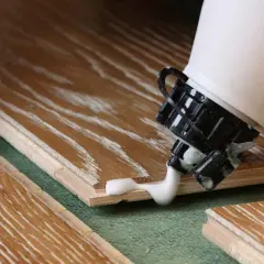 Application de colle sur du bois stratifié. Pour savoir comment enlever de la colle sur du bois stratifié, il faut agir vite.