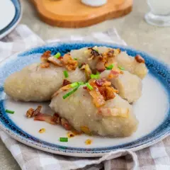 Kartacze z mięsem, przepis babci, podane z chrupiącym boczkiem i szczypiorkiem. Pyszne danie, które zawsze smakuje jak u mamy.