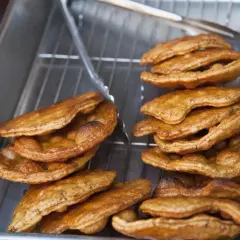 Golden brown, freshly fried Japanese rice crackers cooling on a rack. This image captures the essence of a delicious Japanese rice crackers recipe.