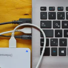 Externe Festplatte wird als USB-Laufwerk erkannt. Kabel verbinden die Festplatte mit dem Laptop.