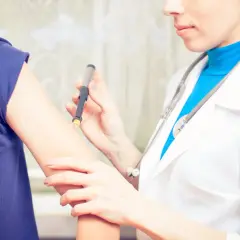 Lekarz od cukrzycy podaje pacjentowi zastrzyk z penem insulinowym.