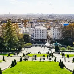 Blick über das Montmartre Viertel in Paris. Menschen genießen den sonnigen Tag im Park mit Blick auf die Stadt.