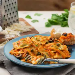 Délicieux ravioli ricotta épinard, une recette italienne savoureuse, servie avec une sauce tomate, des olives et des câpres.