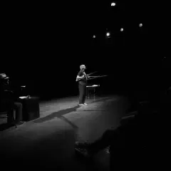 Na scenie Teatru Rondo w Słupsku kobieta z karabinami, mężczyzna w kapeluszu siedzi przy biurku.