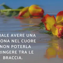 Rose bagnate sulla sabbia, un'immagine che evoca il dolore di come dimenticare un amore non corrisposto, quando il cuore desidera un abbraccio negato.