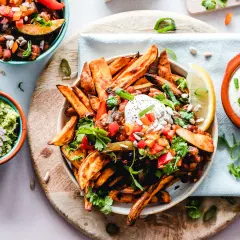 Kolorowe frytki z batatów z salsą, guacamole i śmietaną. Zdrowe jedzenie, które może pomóc w kontroli triglicerydów.