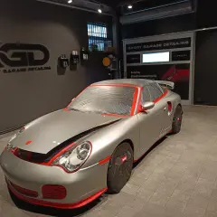 Auto sportiva pronta per il detailing. La carrozzeria è coperta per proteggerla durante il processo di come lucidare la macchina.