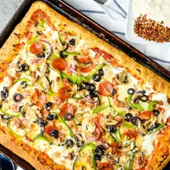 Pyszny przepis na pizzę z serem, pepperoni, pieczarkami, papryką i oliwkami. Idealna na rodzinny obiad.