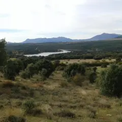 Paisaje con embalse y montañas al fondo, evocando la belleza de las paredes de Buitrago.