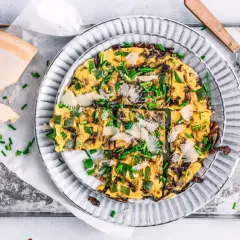Herzhafte Frittata mit Paprika, Zwiebeln und Parmesan, garniert mit Schnittlauch. Perfekt für schnelle 15 Minuten Rezepte.