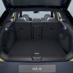 Vue du coffre ouvert d'une Volkswagen ID.4 jaune. Le volume du coffre est spacieux, prêt à accueillir vos bagages pour un long voyage.