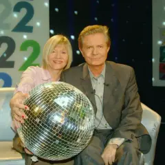 Krzysztof Szewczyk z partnerką i kulą dyskotekową na tle cyfr 222.