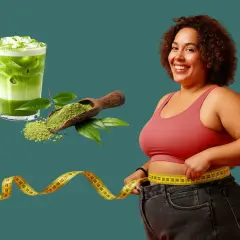 Frau misst ihre Taille mit einem Maßband, neben einem Glas Matcha-Eisgetränk und einem Löffel Matcha-Pulver. Matcha zum Abnehmen kann helfen!