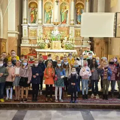 Dzieci w kościele, każde z różańcem w ręku, zastanawiają się, czy można samemu poświęcić różaniec.