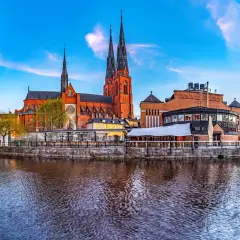 Uppsala domkyrka och stadsteatern speglar sig i Fyrisån. En vacker vy av vad det finns att se i Uppsala.