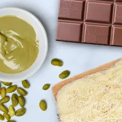 Zutaten für ein **Rezept Dubai Schokolade**: Pistaziencreme, Schokoriegel, Kataifi-Teig und ganze Pistazien.