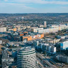 Widok na Rzeszów z lotu ptaka. Widać nowoczesne budynki, centrum handlowe i osiedla mieszkaniowe. Ceny mieszkań Rzeszów są tu widoczne w kontekście rozwoju miasta.